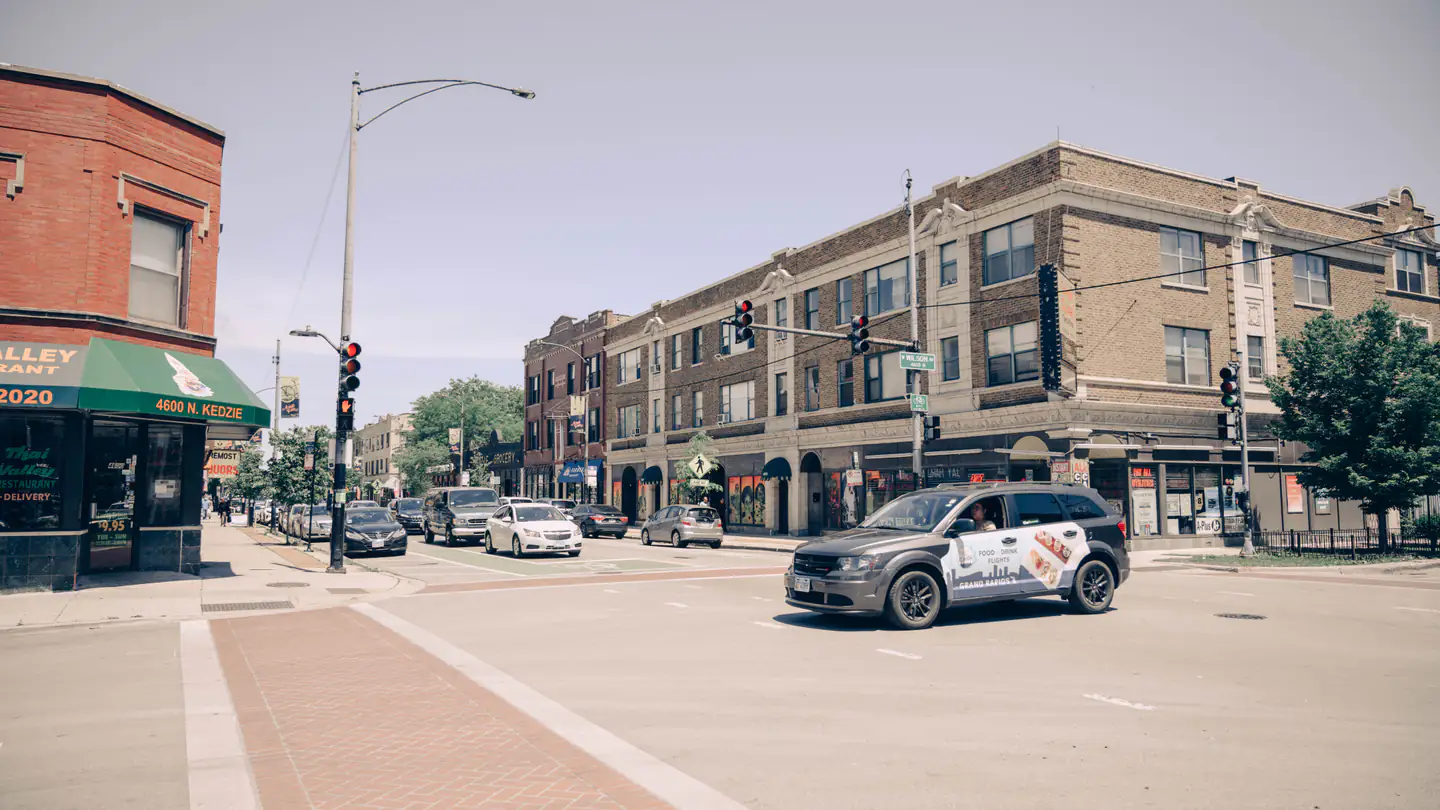 A city intersection lined with two- and three-story brick buildings with storefronts at street level.