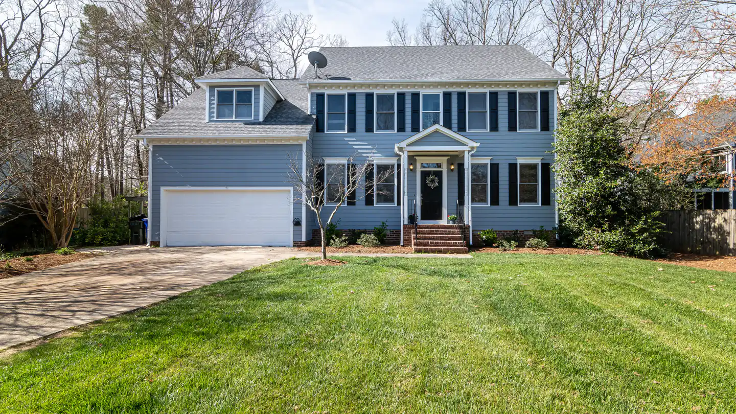 A two-story suburban house with an attached two-car garage and a wide front lawn.